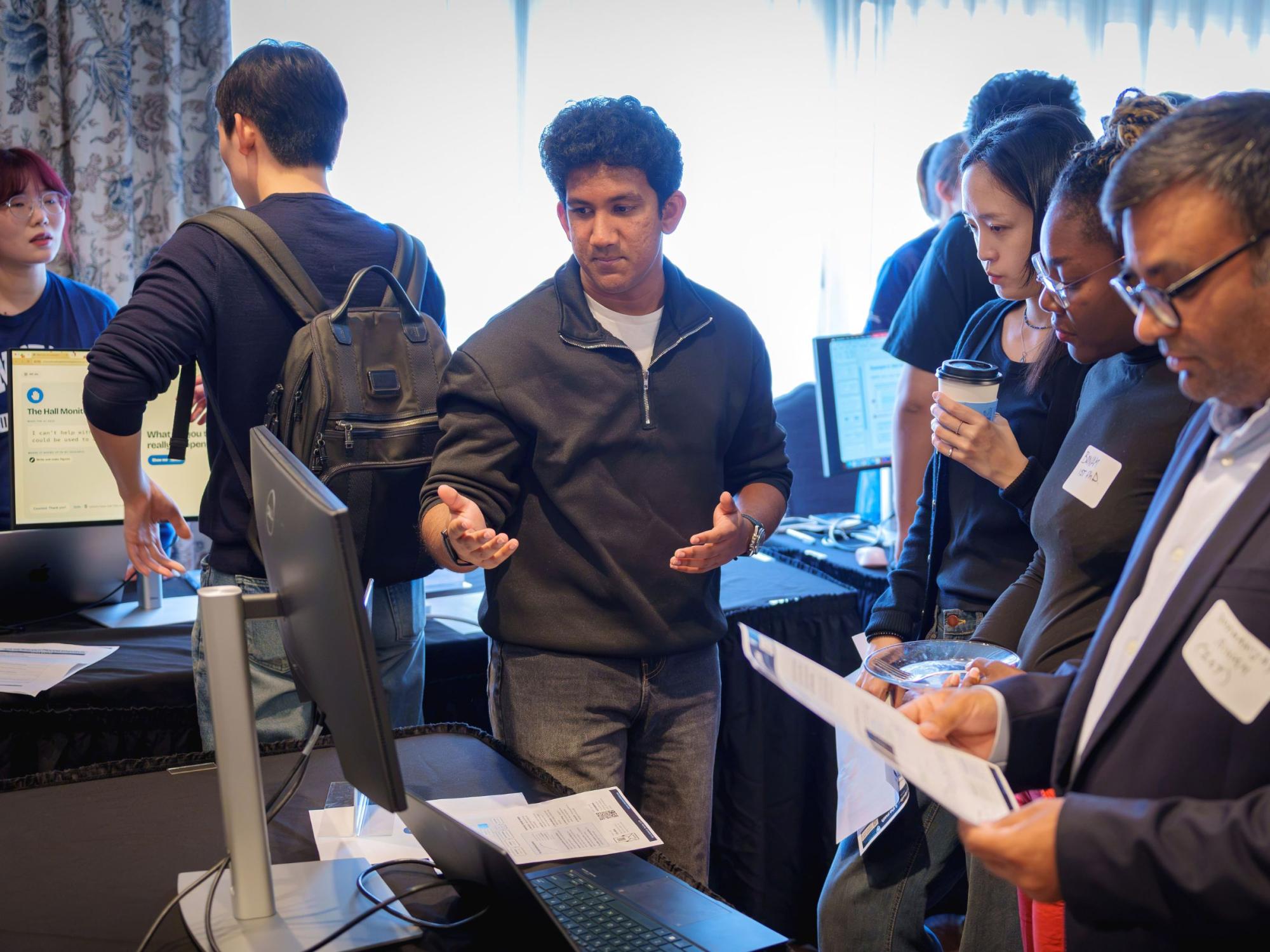 college students share laptop presentations with faculty 
