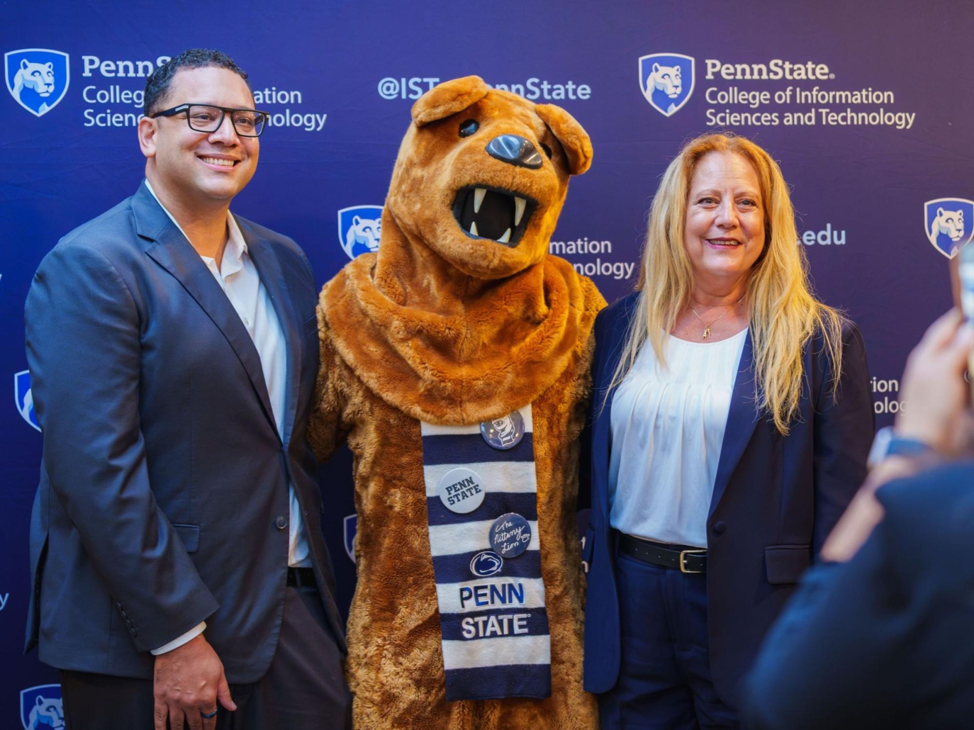 two people take a photo with the Penn State Nittany Lion