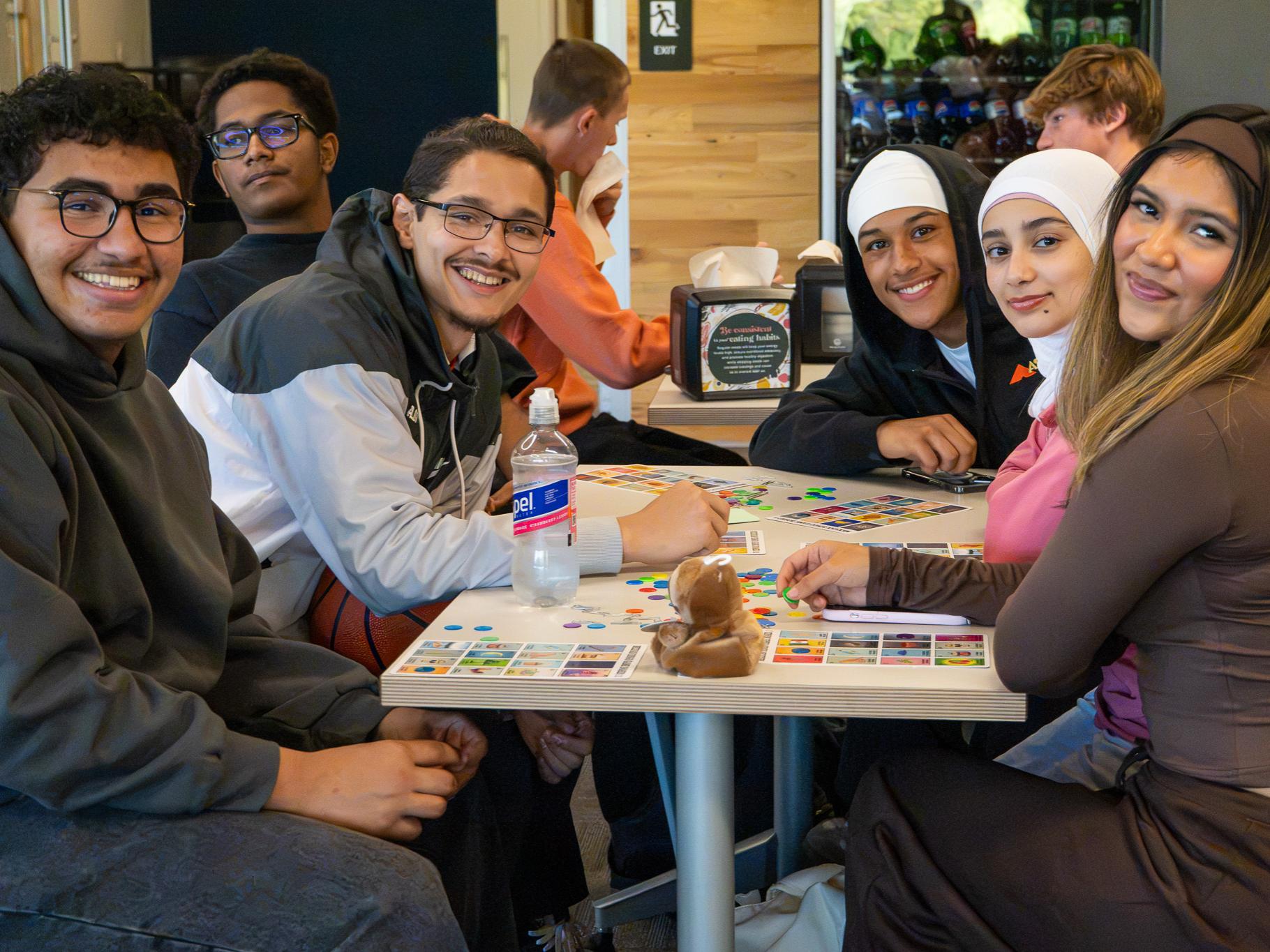 group of people sitting at a table smiling at the camera