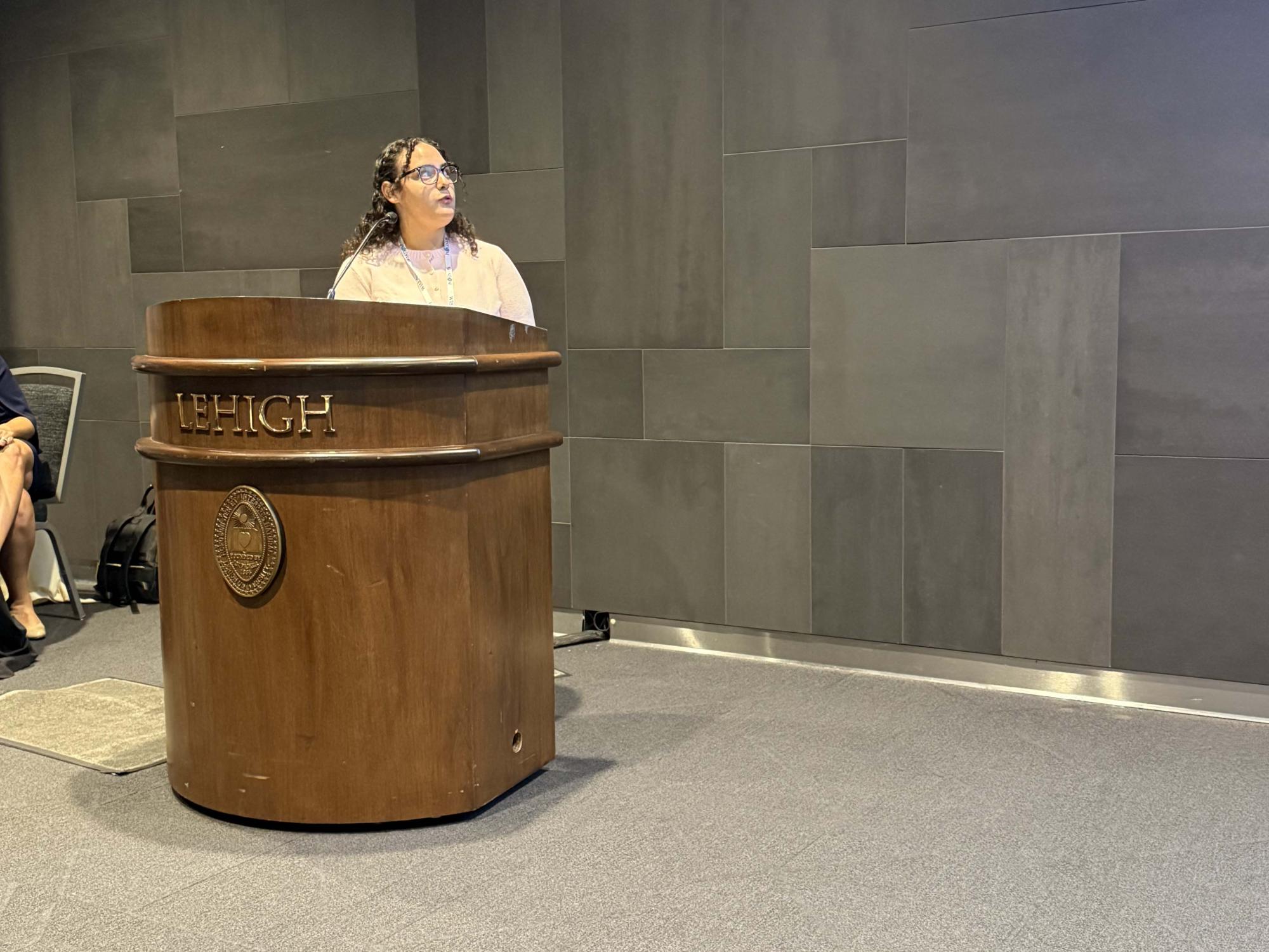 girl standing at podium looking to her left during a presentation