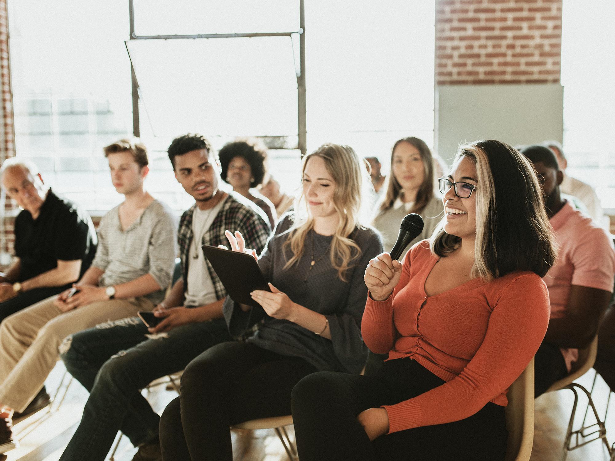 Cheerful woman speaking on a microphone in a workshop