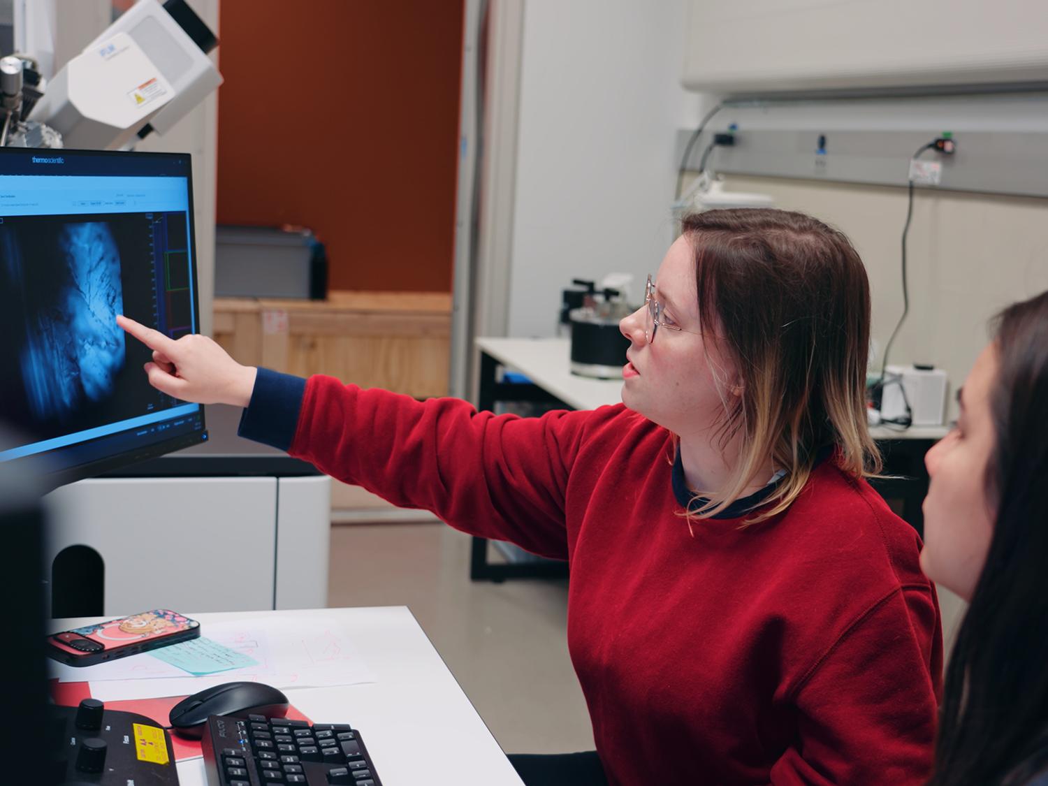 Jessica Thompson, a chemistry graduate student, gestures to a display during her 2025-26 assistantship with the Cryo-Electron Microscopy Facility