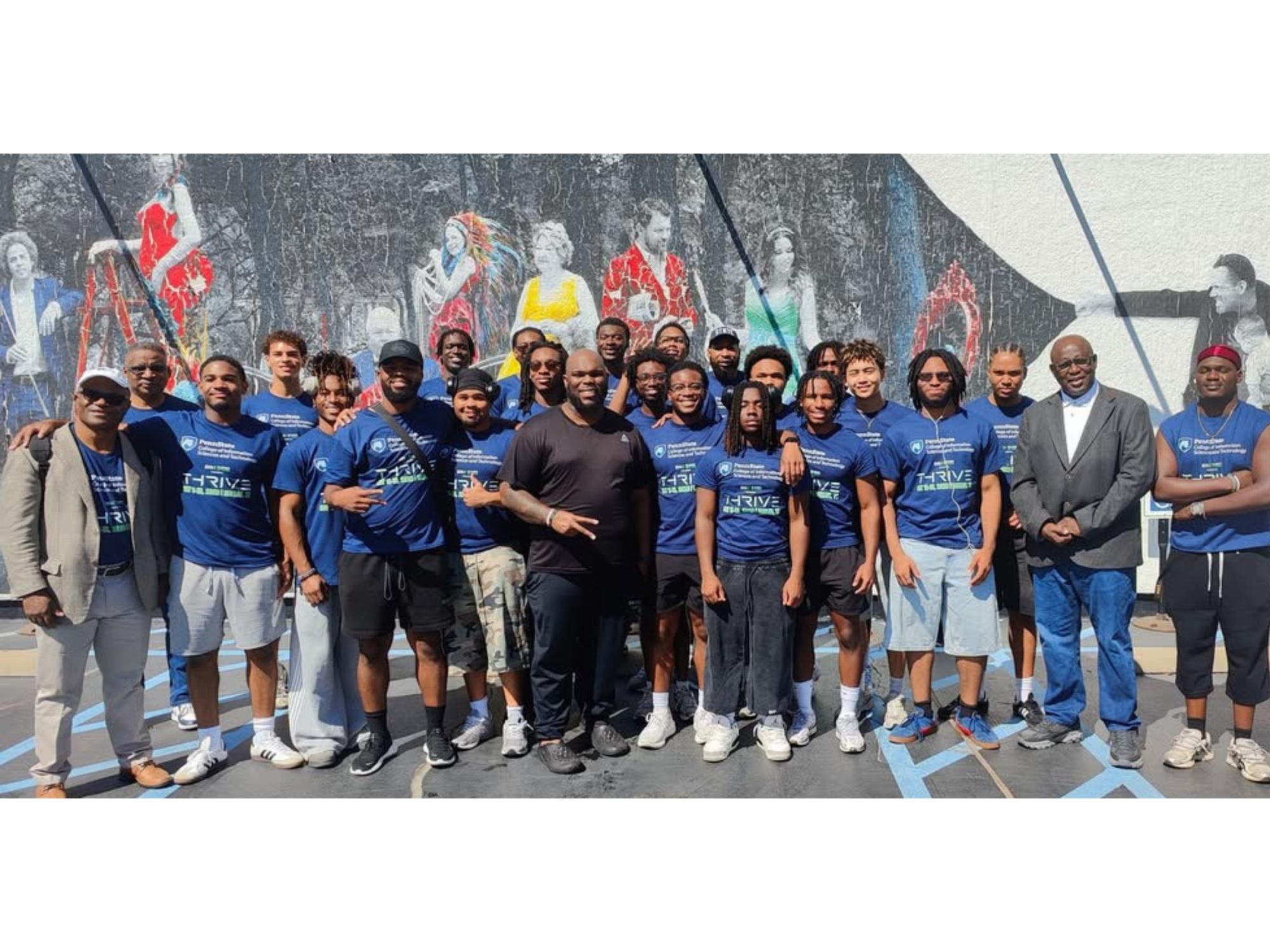 large group of people in an urban setting with graffiti wall in background