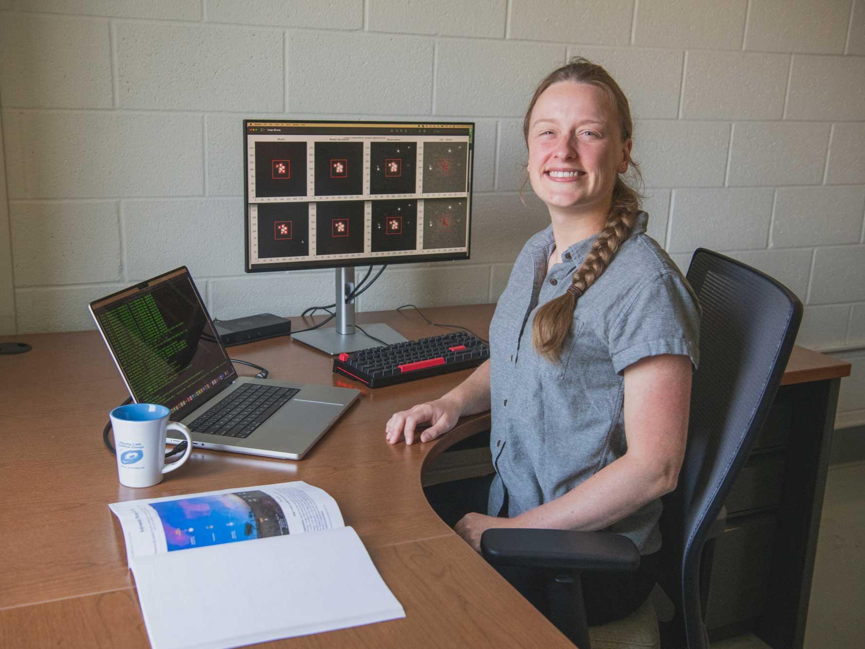 Charlotte Ward in her office, with laptop and computer monitors