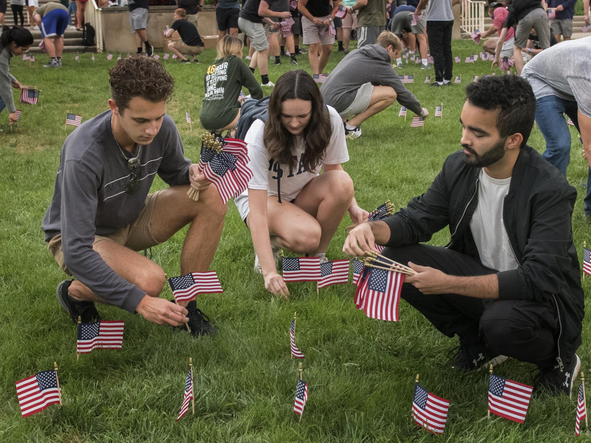 students placing flags on lawn