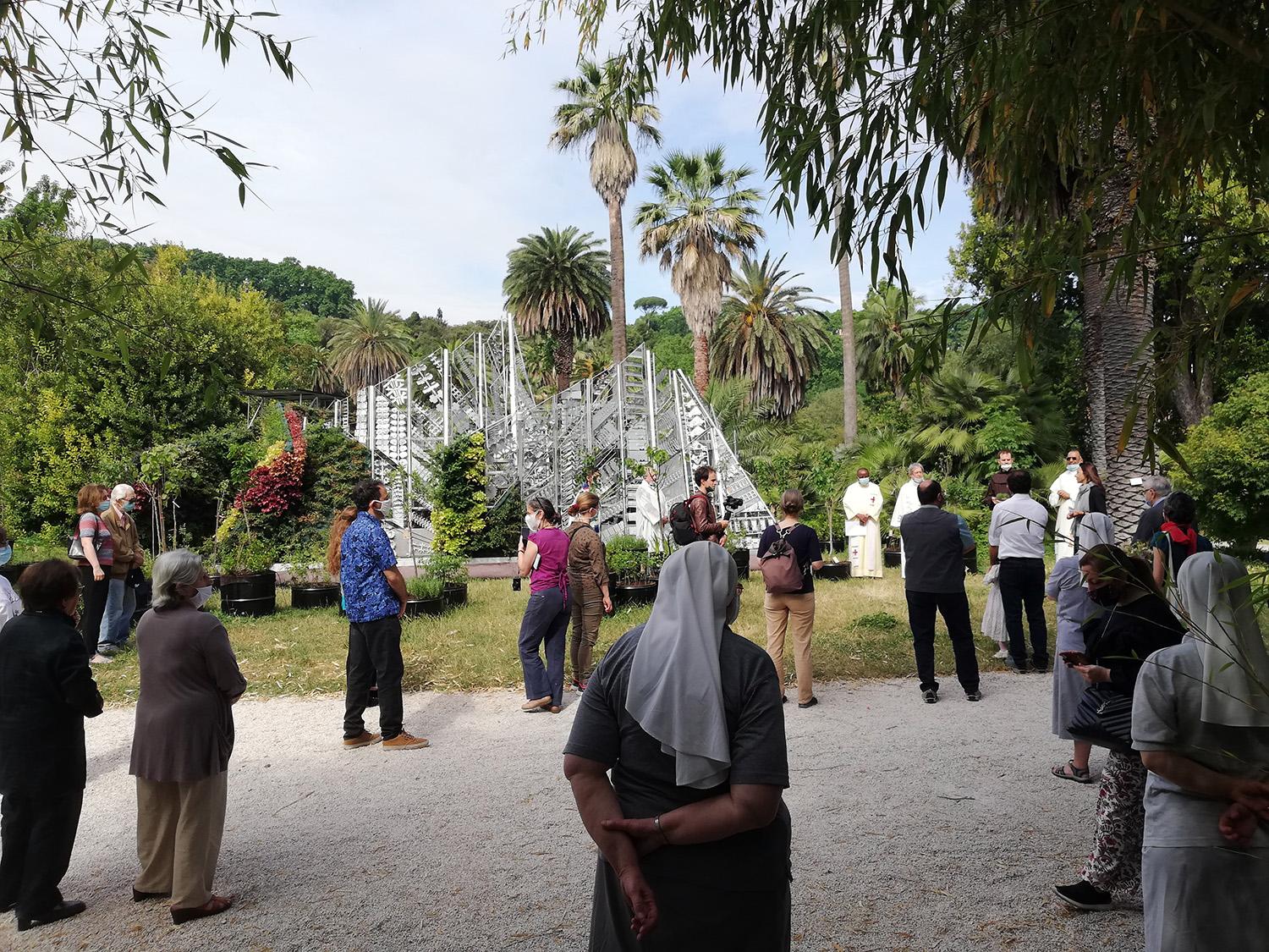 The Living Chapel in the background with a small Catholic mass in the foreground while people wear masks.