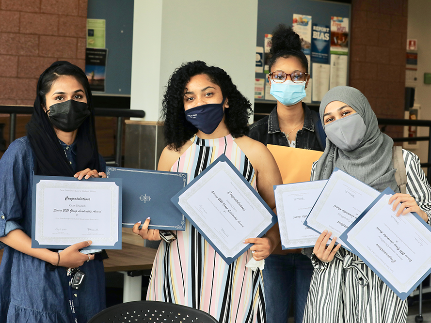 A group of female students sharing their award certificates.