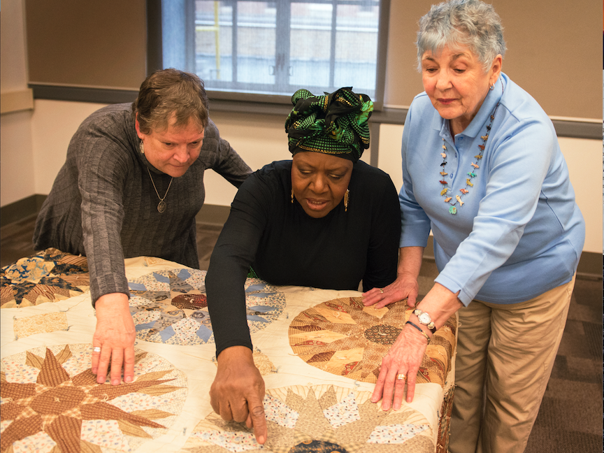 Weaving Wisdom team with old quilt