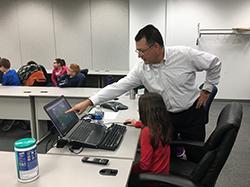 Eric Donnell shows elementary school student how to play the traffic control game