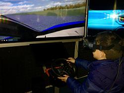 elementary school student drives a virtual reality driving simulator