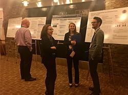 male and female students discuss research posters