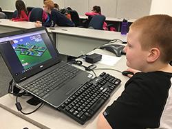 young male student plays computer game