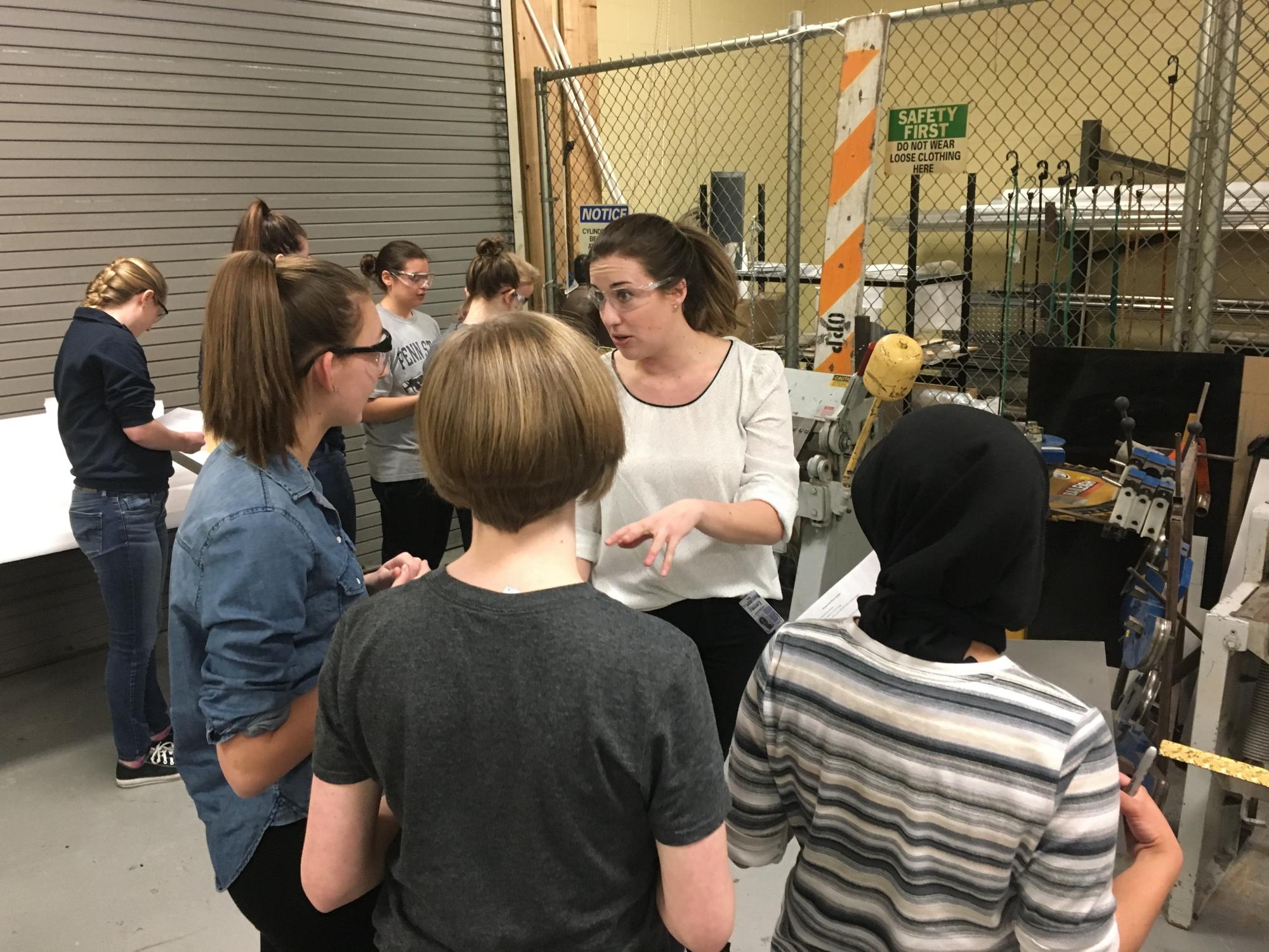 A group of people listen to a woman talking