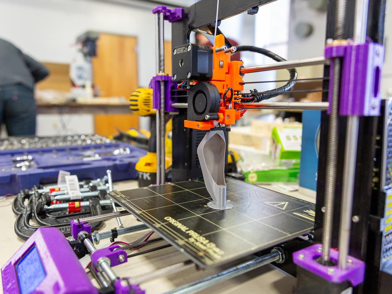 A close up of a 3d printer printing a specially designed cup. 