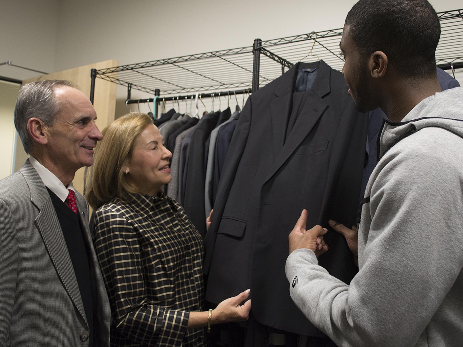 Chancellor Mason and Wife with Student looking at suit
