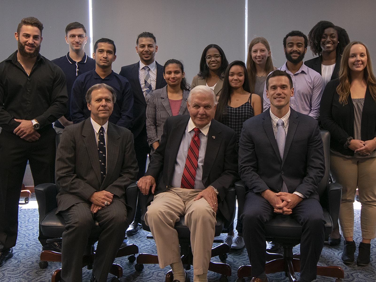 Richard Nese, John Trach, and Patrick Nese posing with students