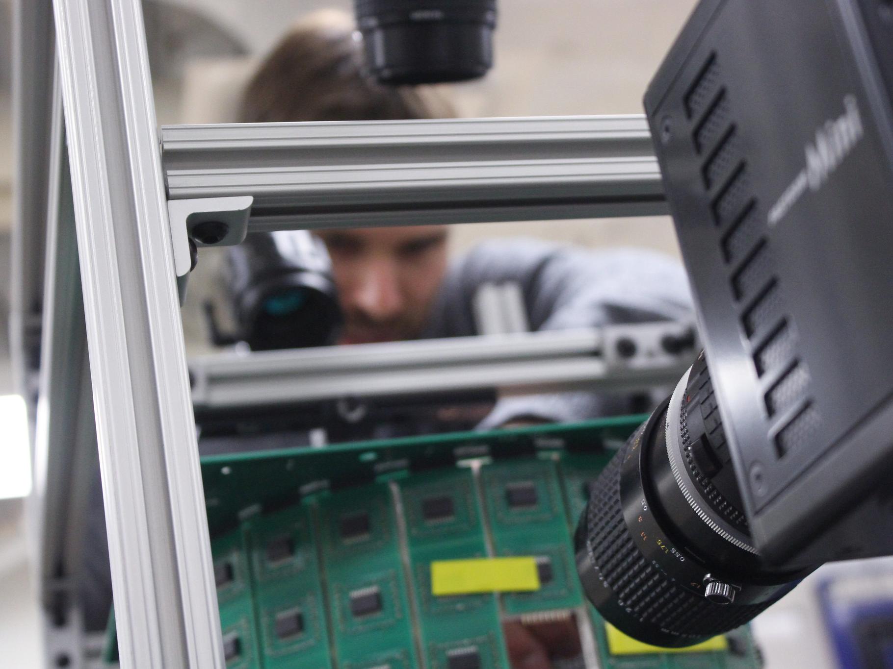 A professor stands in front of a virtual reality simulator for flights, adjusting machinery.