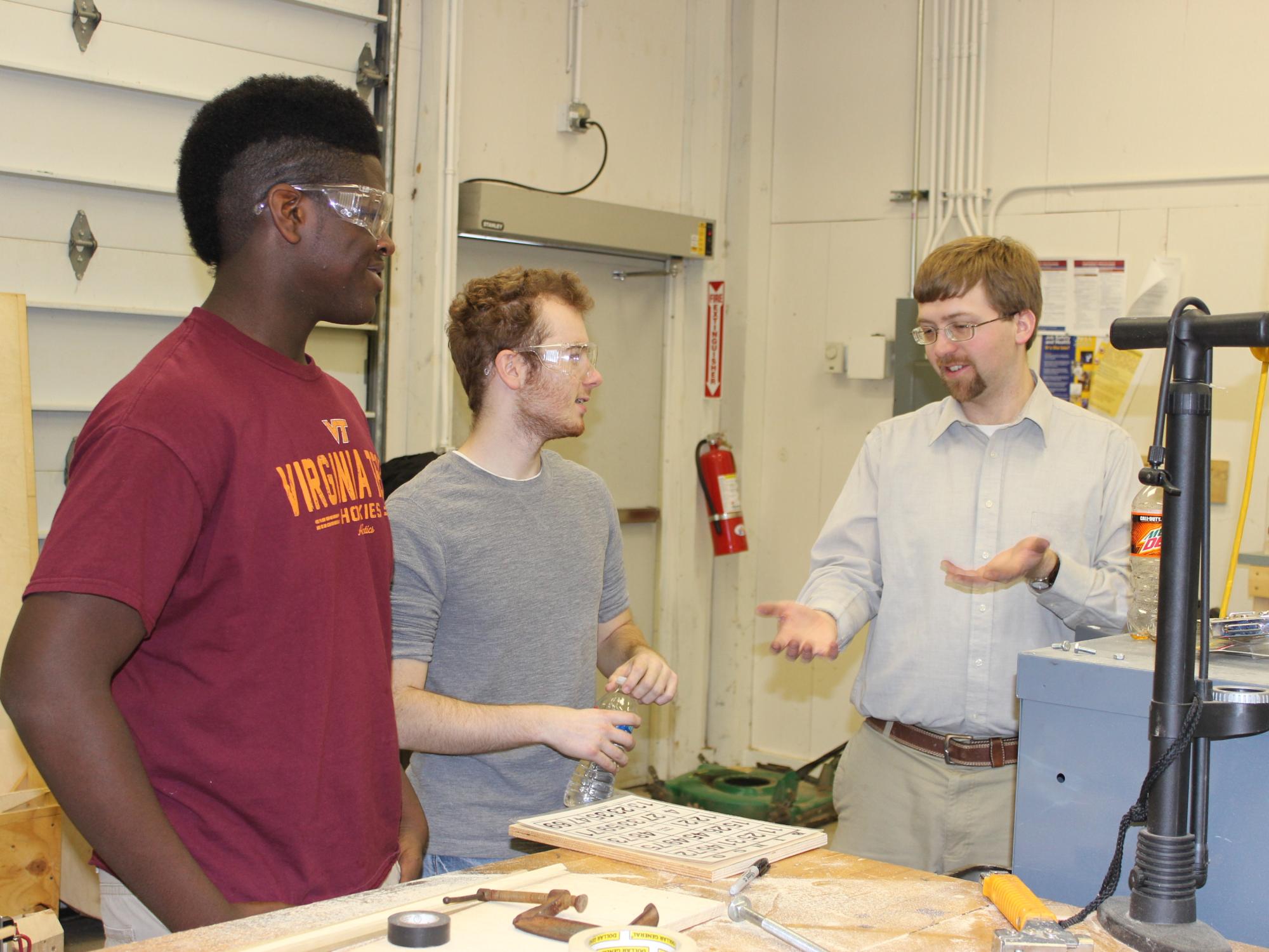 Engineering design students Aubrey Rowley and Chance Wagner receive advice from Dr. Jacob Moore, assistant professor of mechanical engineering.