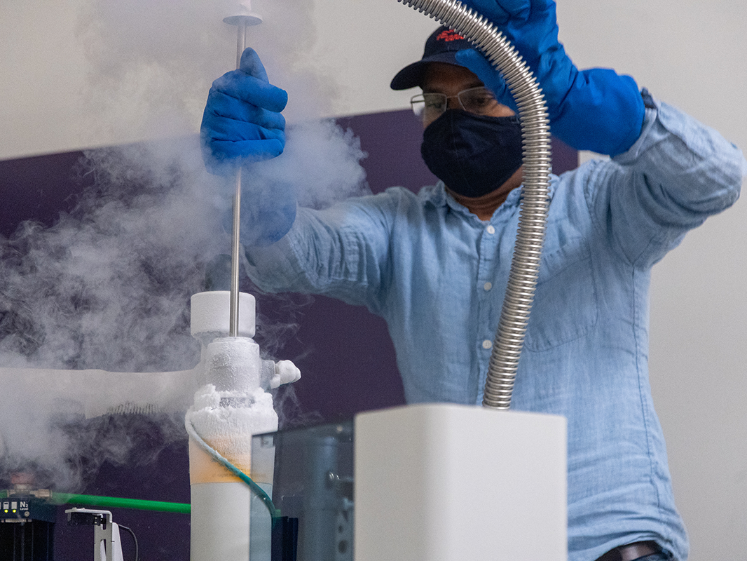 NMR Facility Director Tapas Mal finishes topping off a spectrometer with liquid helium.