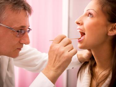 dr. examining patiient's mouth and throat