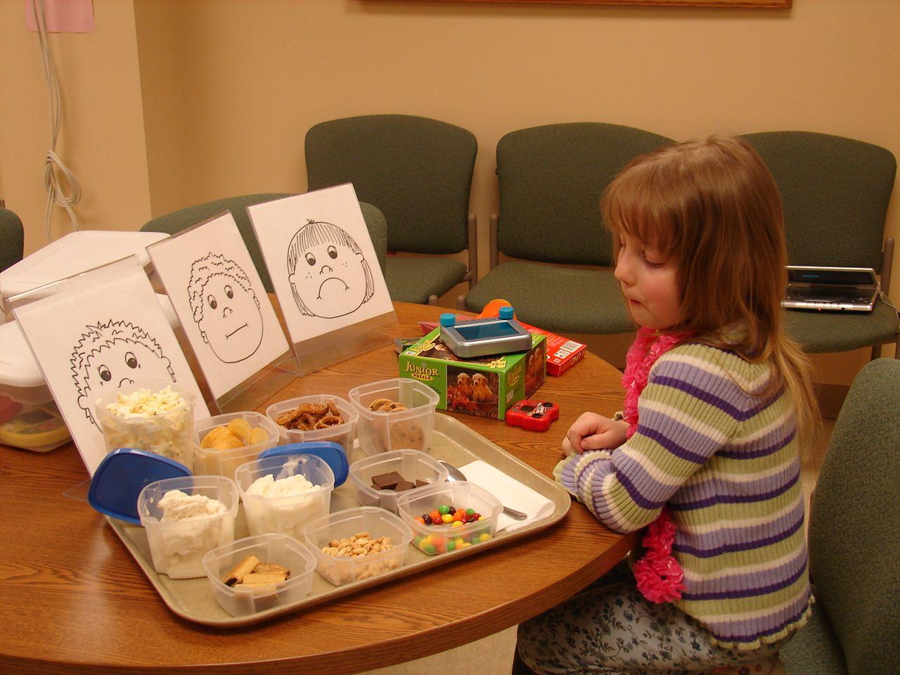 child looking at food and toys