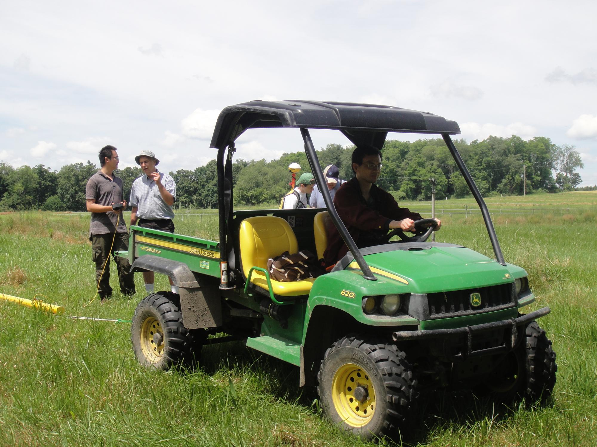 Henry Lin in a green mini-tractor