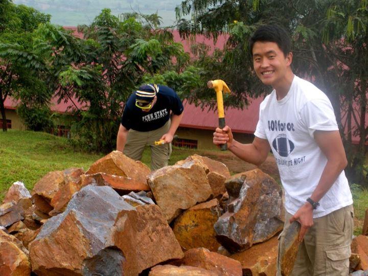 Student crushing stones for greenhouse structure.