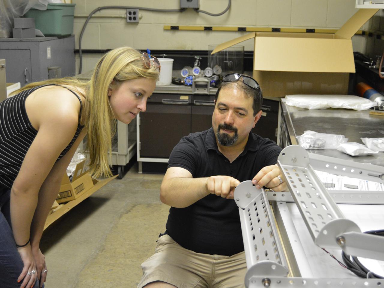 Professor Jeffrey Brownson and energy engineering student Corryn Klien discuss logistics of installing the frame of the solar panel that will power the group’s All-Seeing Eye device