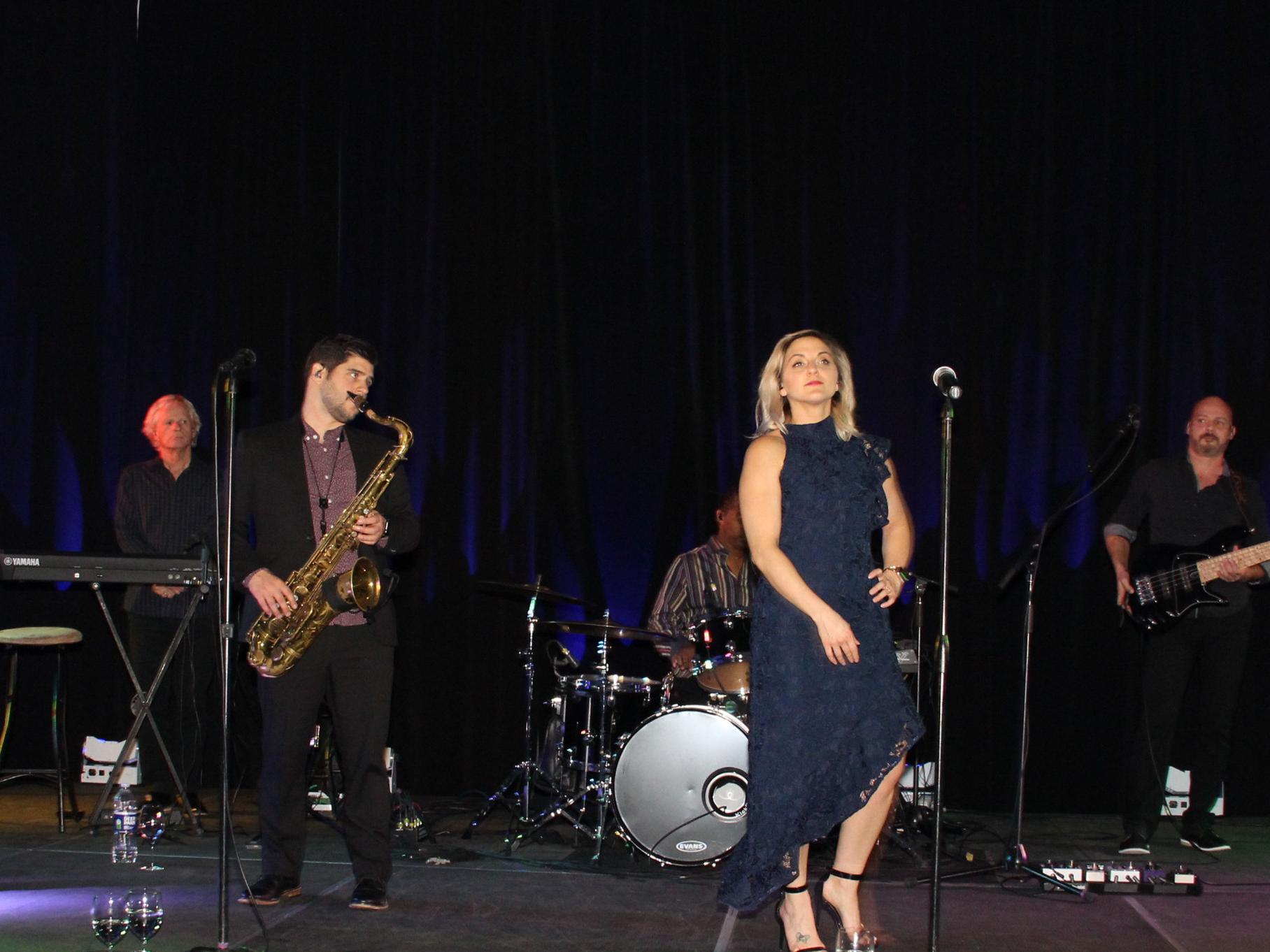 Band on stage playing instruments and singing 
