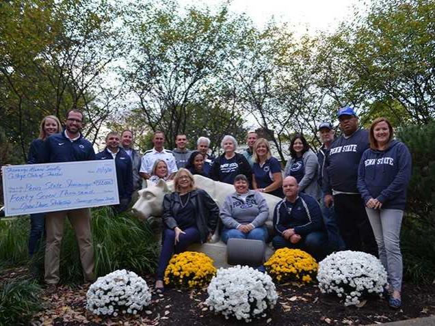 A group of men and women in front of the Nittany Lion at Shenango campus.