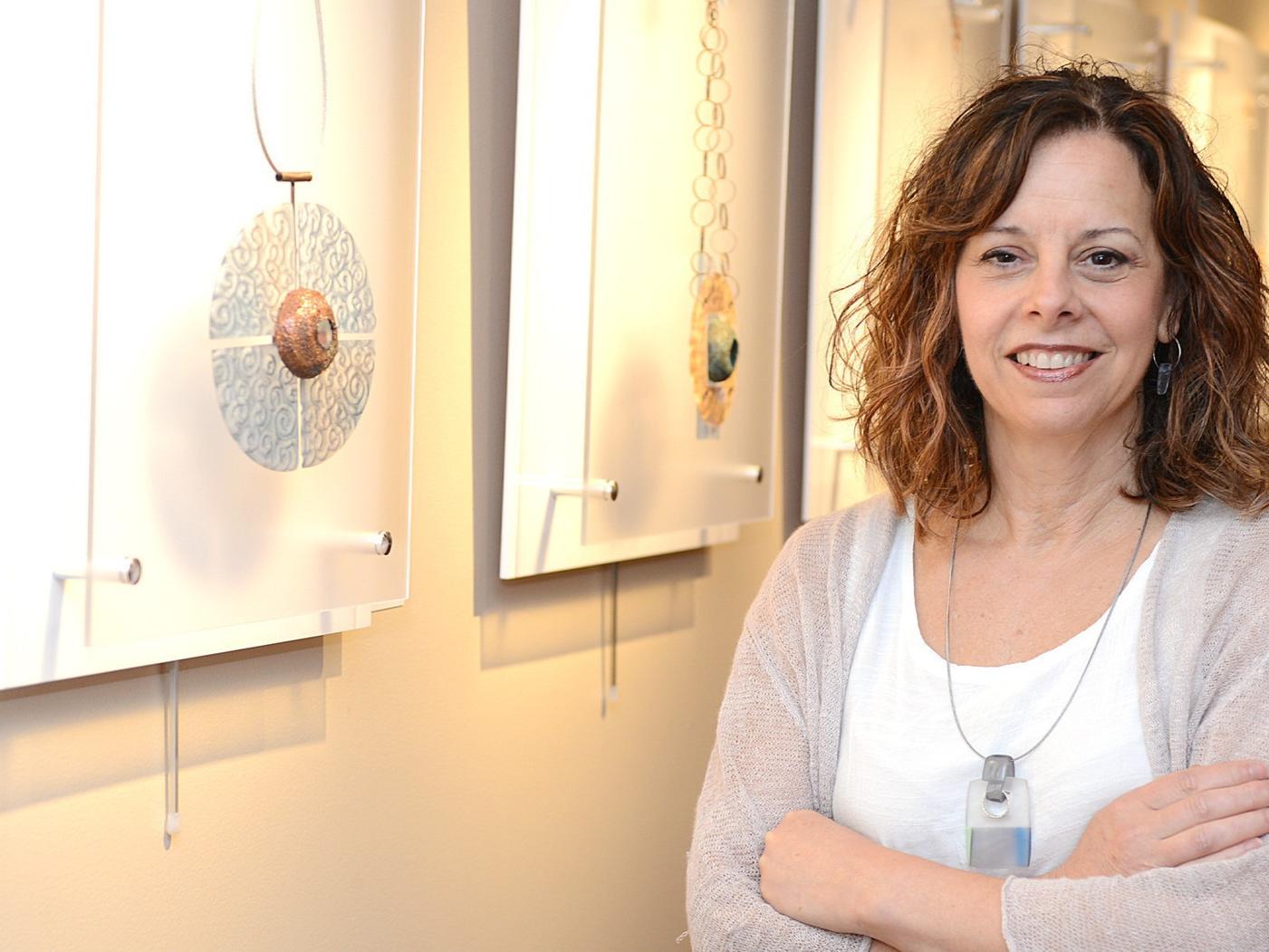 woman smiling in art gallery next to pieces of art