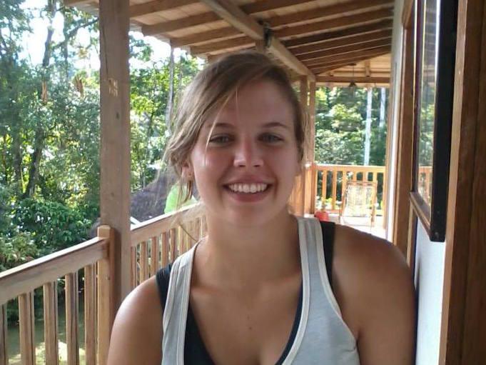 horizontal photo of female graduate student standing on covered porch in Ecuador