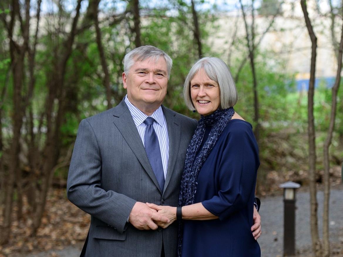 Eric and Molly Barron posing in front of small trees