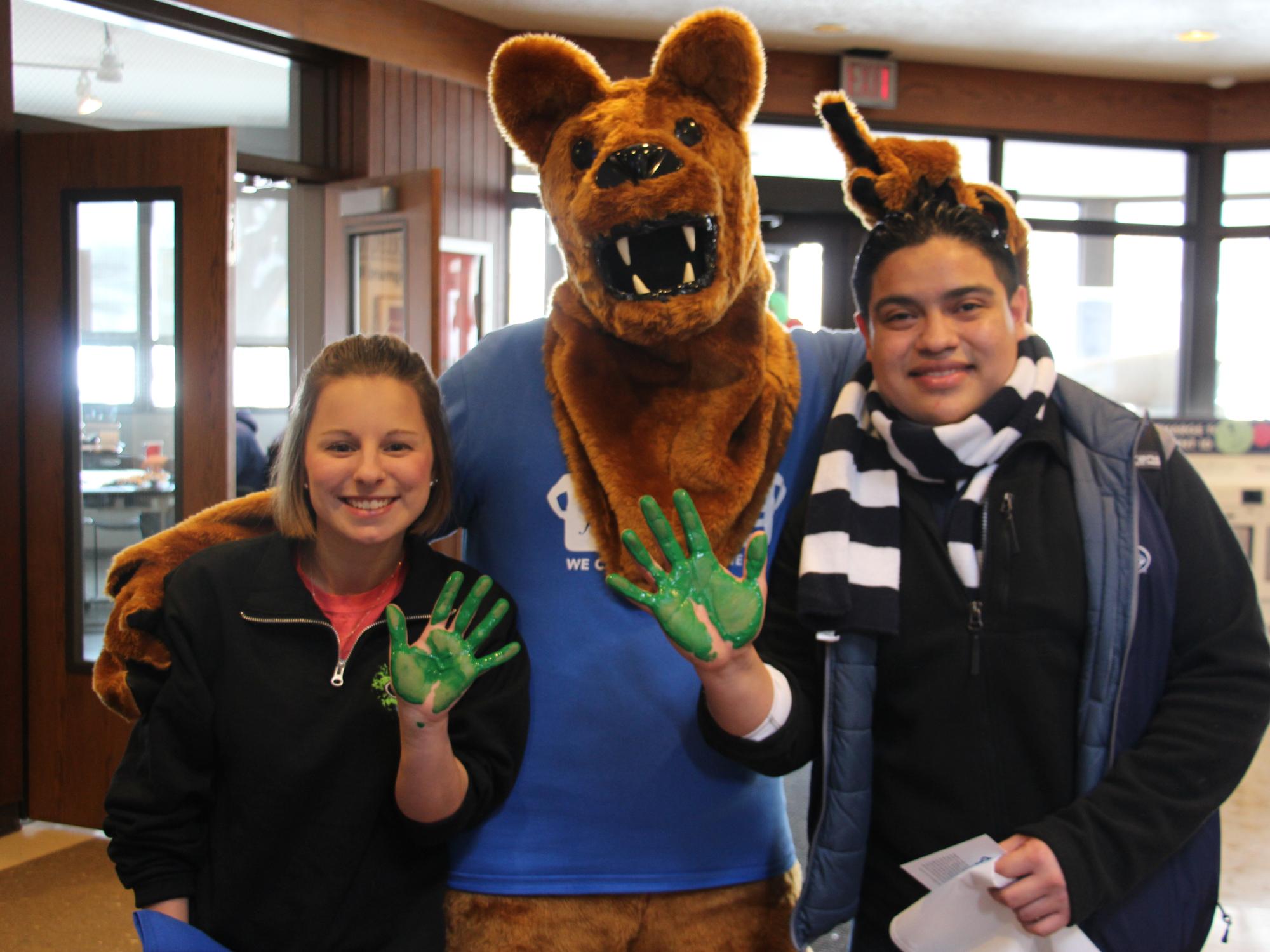 Students with their hands covered in green paint 