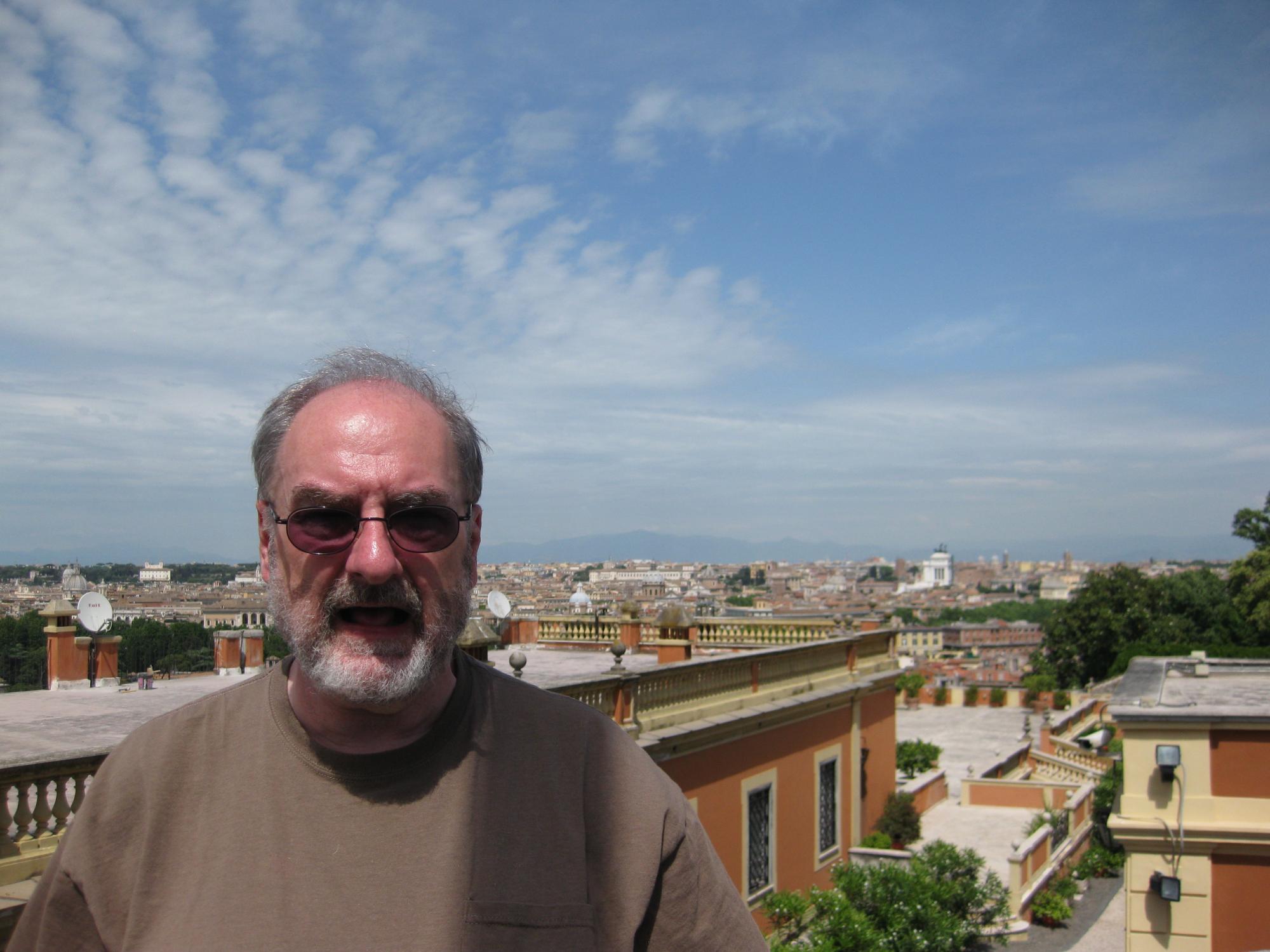 Brian Curran stands with the panoramic view of Rome
