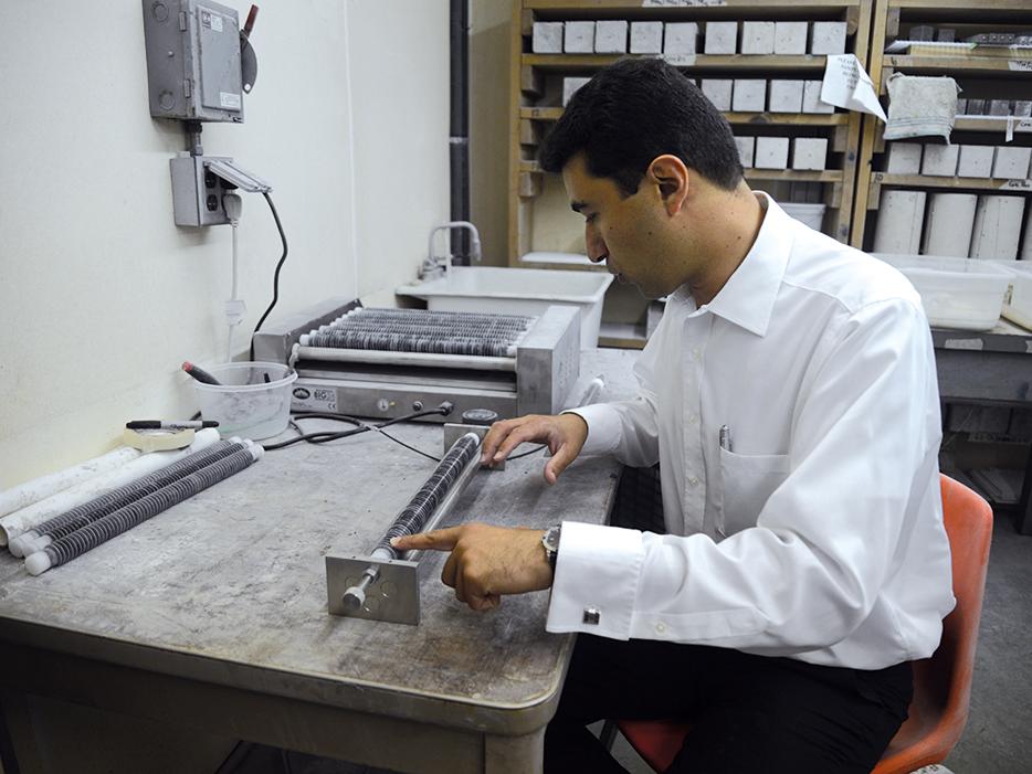 Civil engineer inspects a tube filled with concrete.
