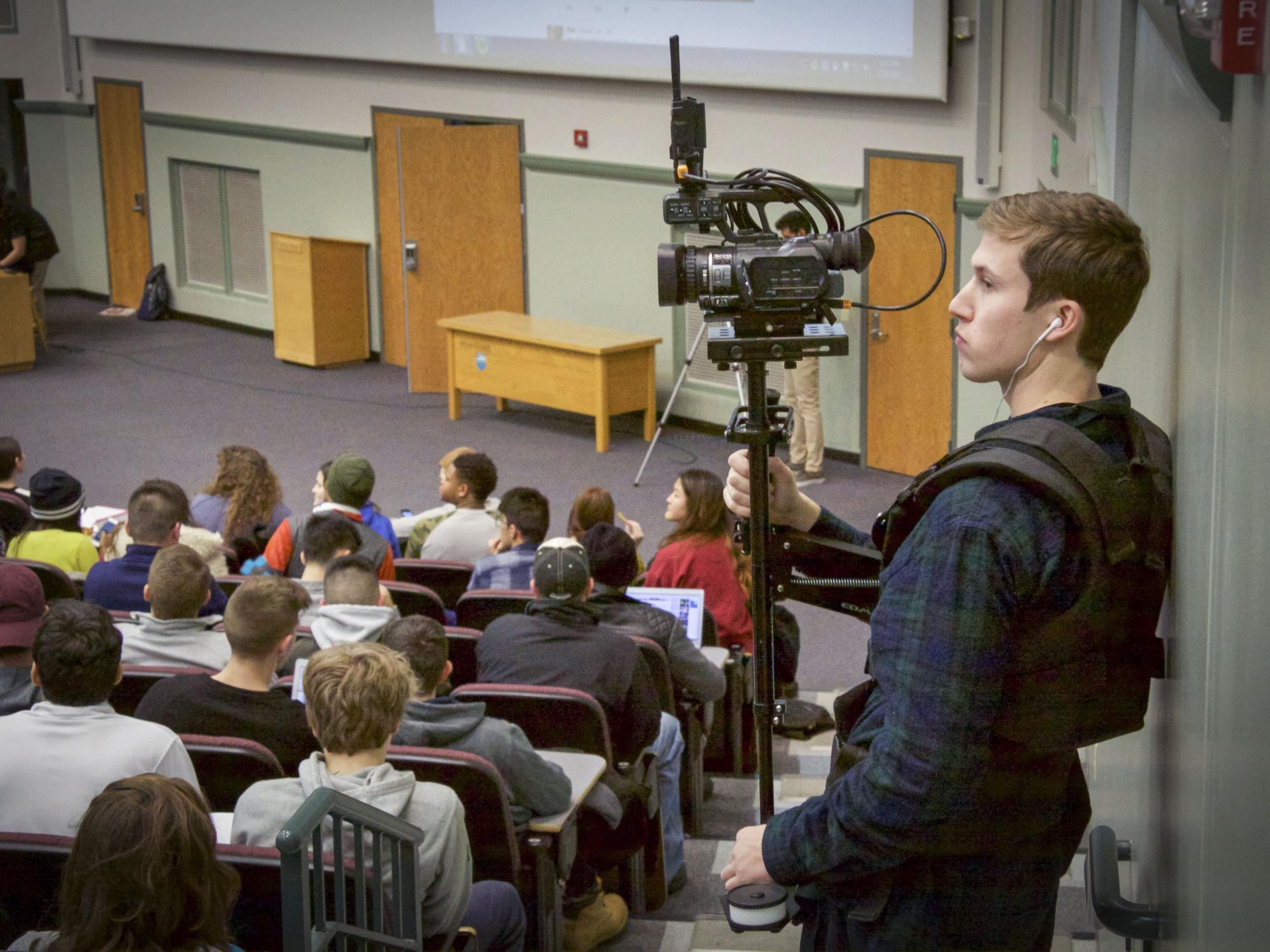 A student holds a camera to film Sam Richards' class