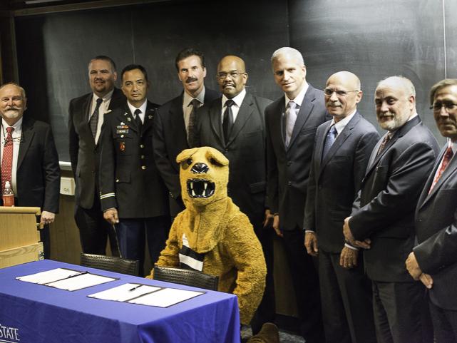 group of people standing with the nittany lion