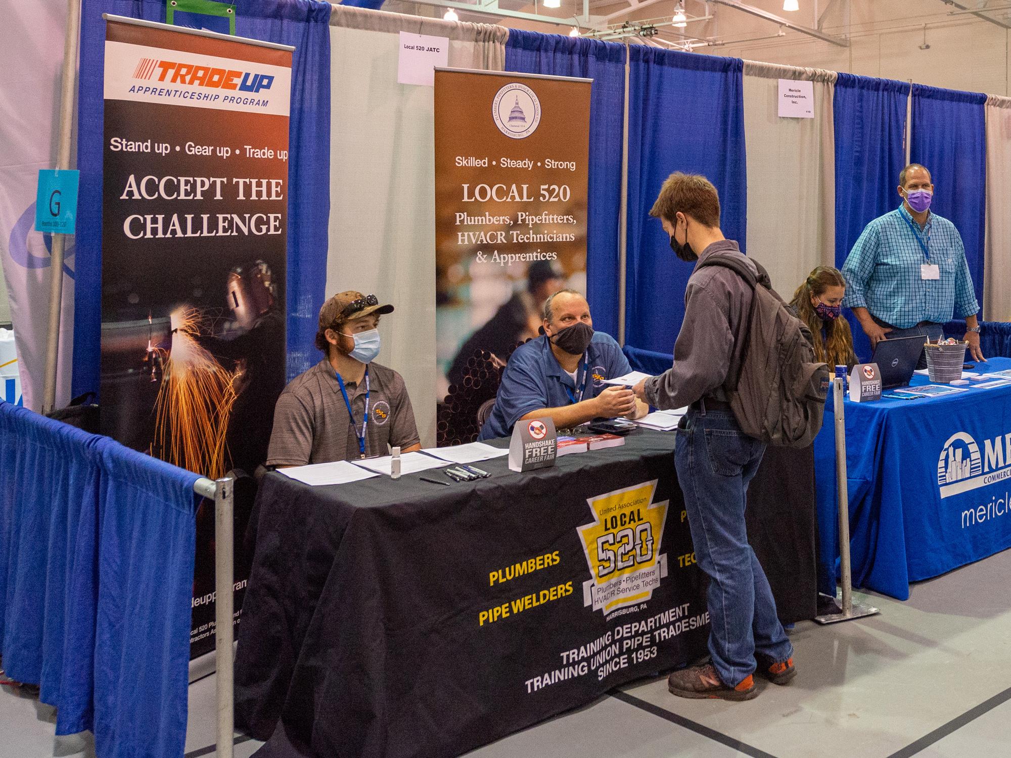 People at an employer's booth at a career fair.