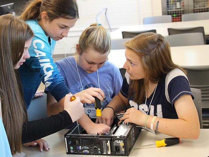 4 of the students participating in the Conference work together to assemble computer hardware.