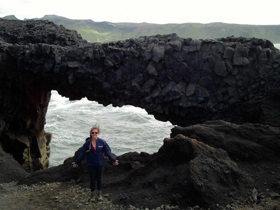 Senior geoscience major Chelsea Eyer stands next to a rock formation in Iceland