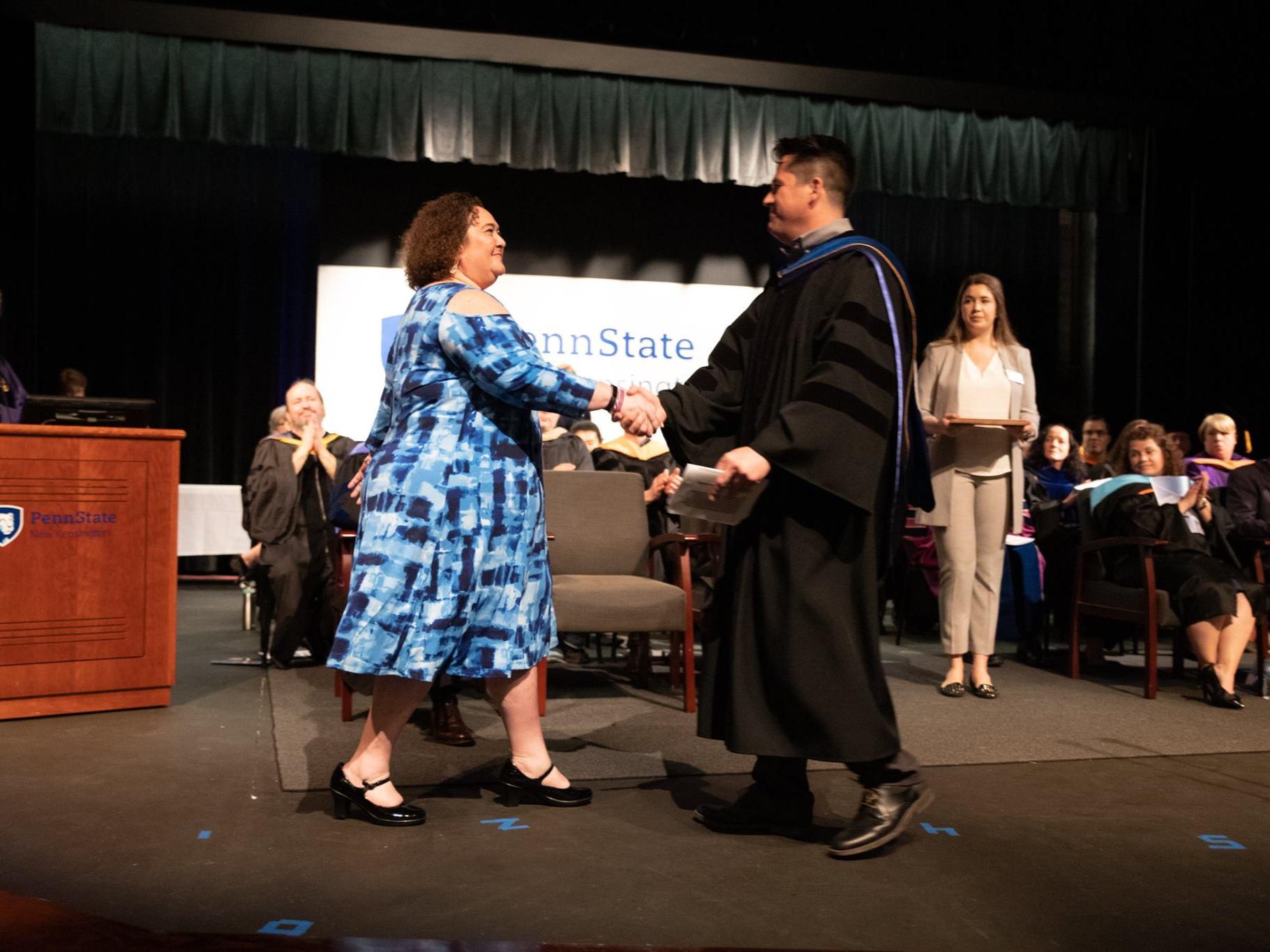 Woman accepts award from man on stage