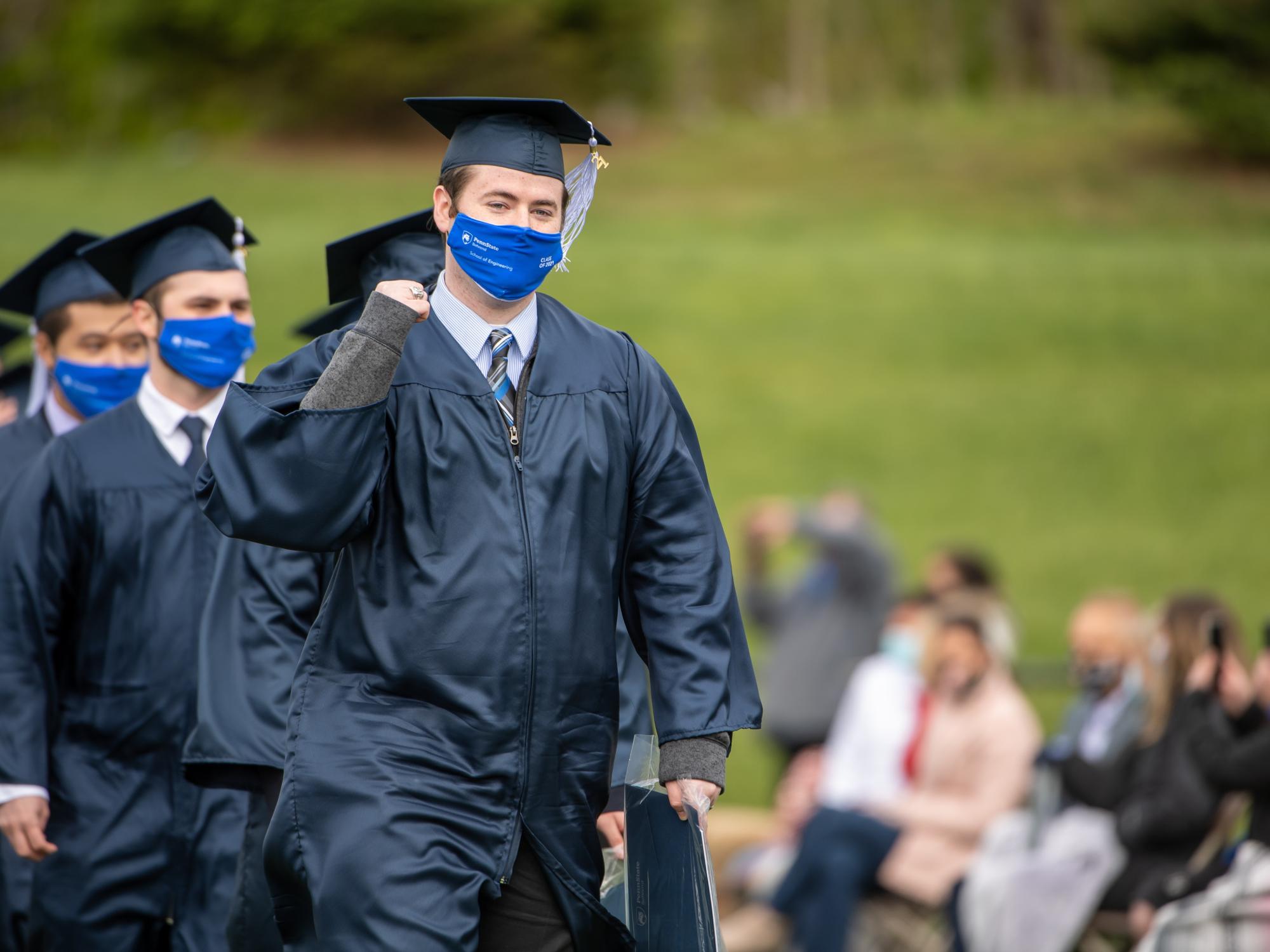 Penn State Behrend graduates celebrate as they leave the field after commencement.