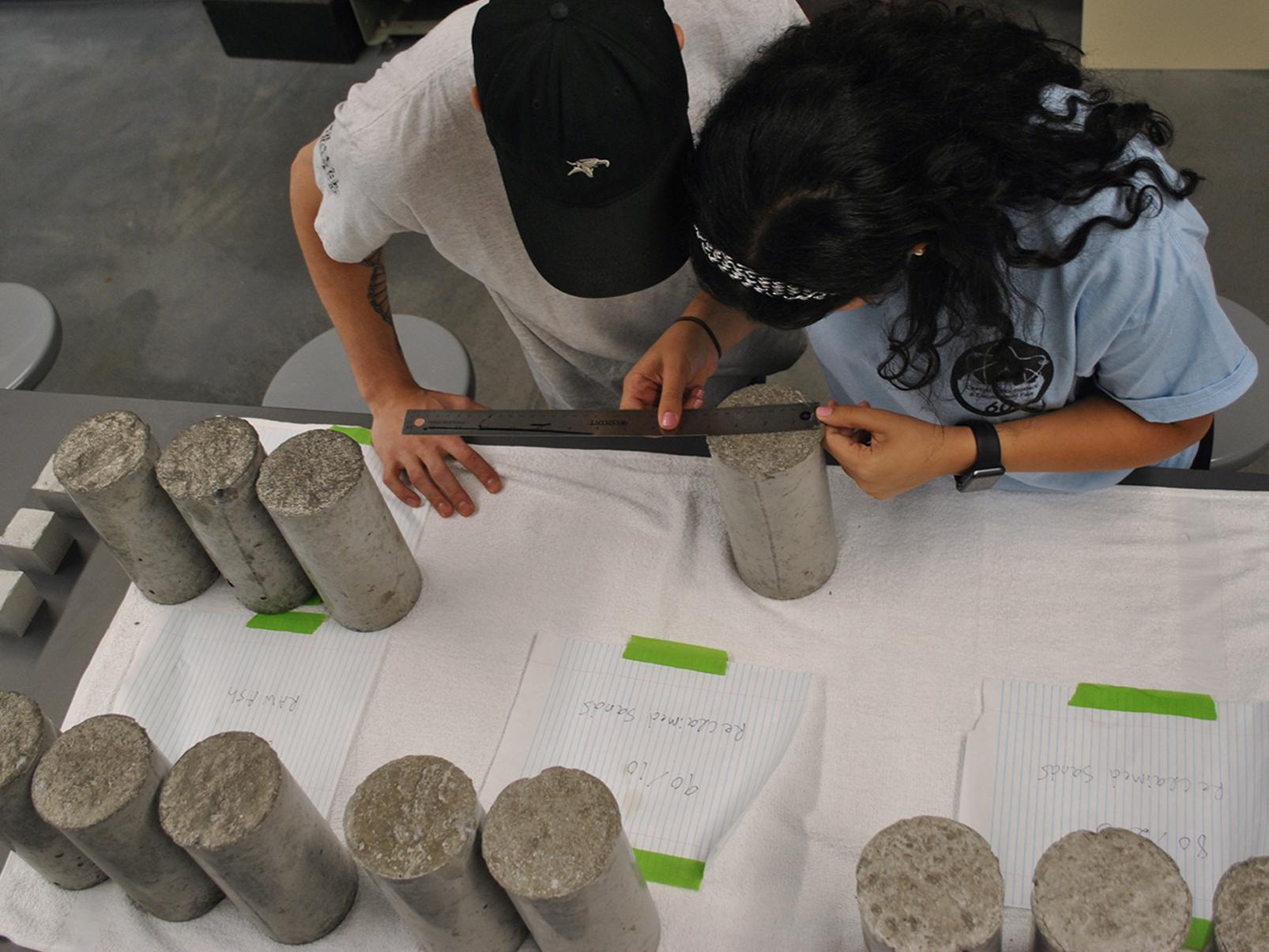 Students Kienan Dalesandro and Martina Soliman testing concrete samples