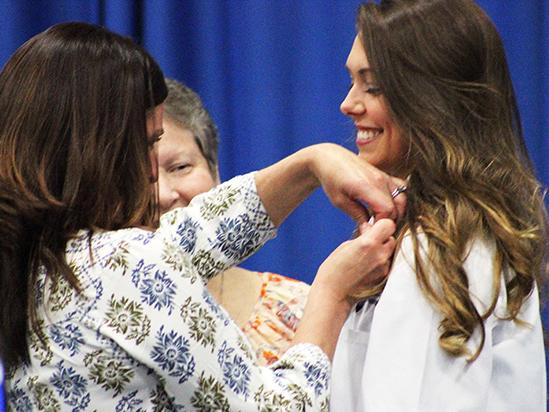 Nursing student Sidney Crain is pinned by a family member.