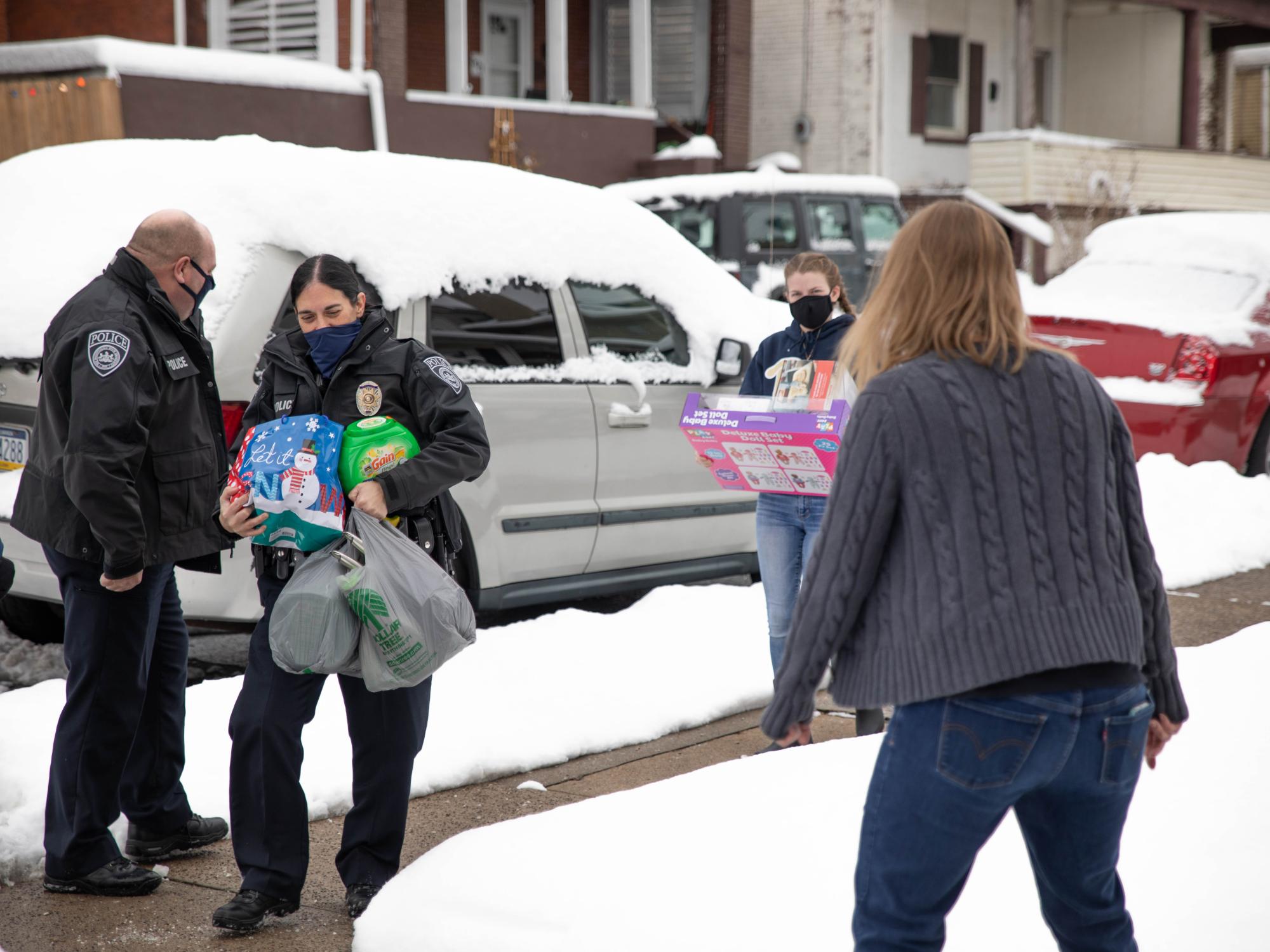 Individuals carrying gift bags and items