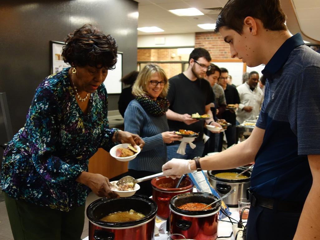 Student serves food to community member at New Kensington