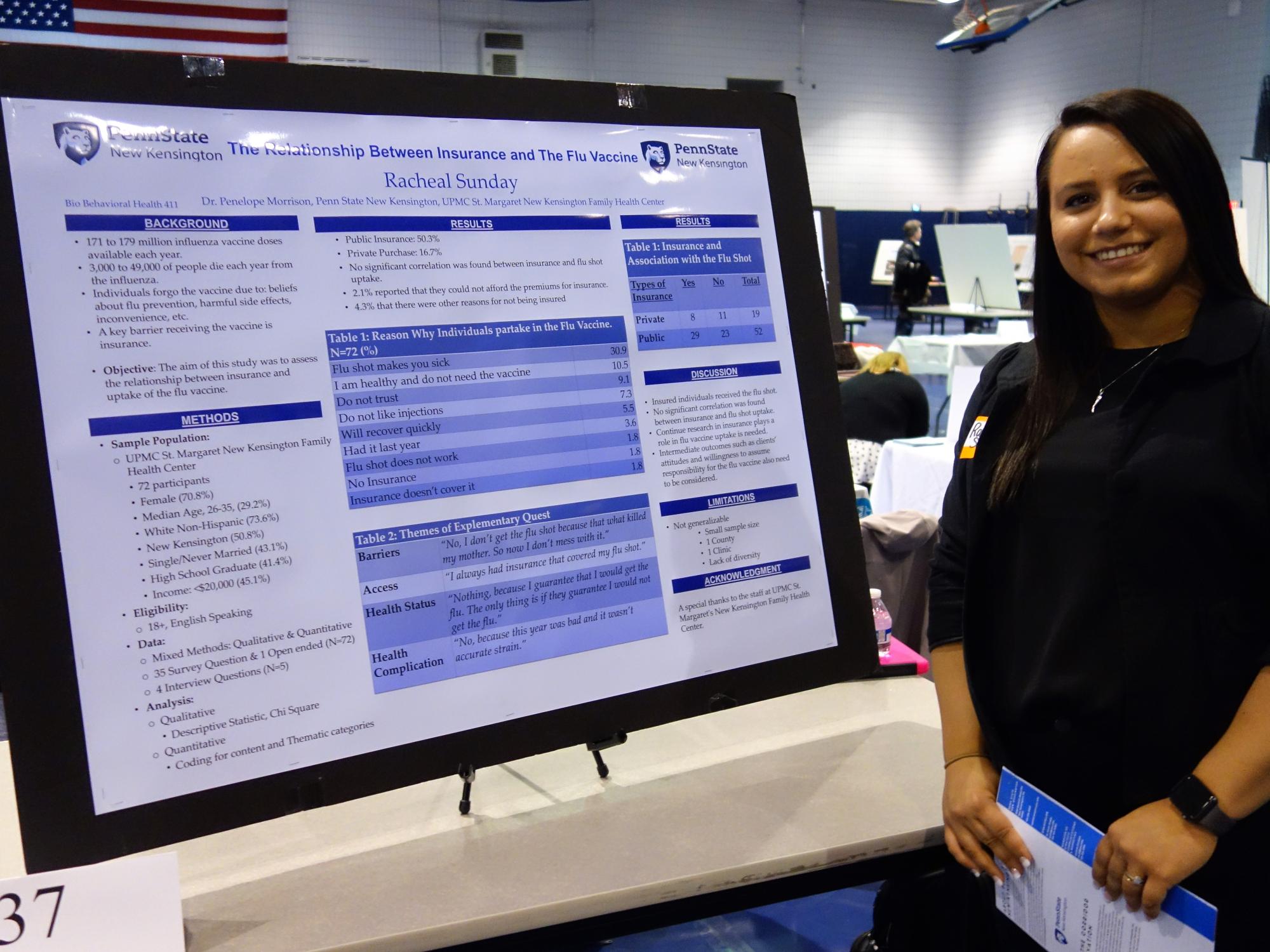 Racheal Sunday, student, stands next to her research poster