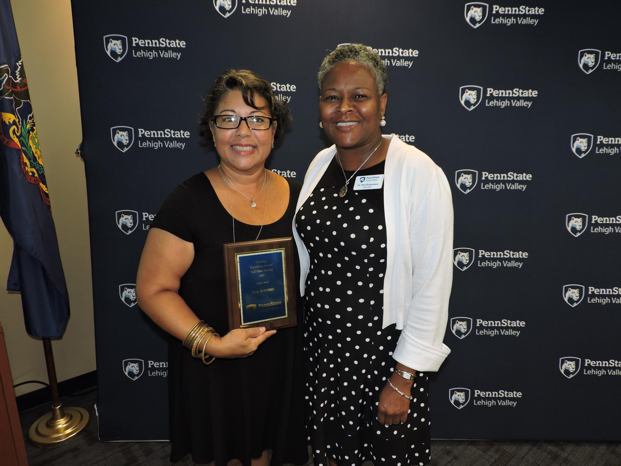 two women holding an award