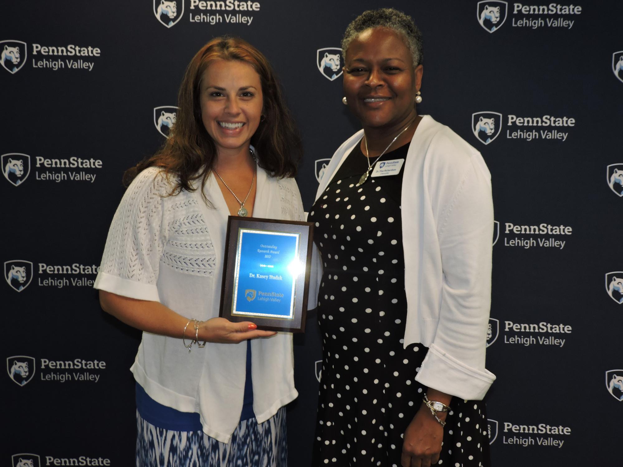 two women holding an award